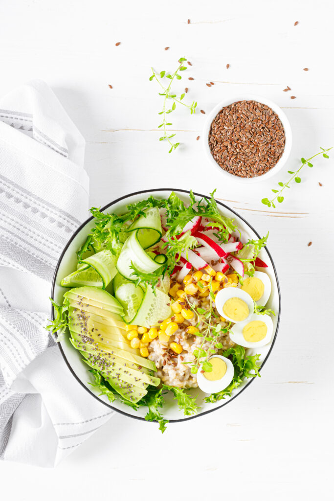 breakfast-oatmeal-porridge-with-fresh-vegetable-salad-cucumber-radish-lettuce-corn-avocado-chia-seeds-boiled-eggs-healthy-balanced-food-top-view-flat-lay