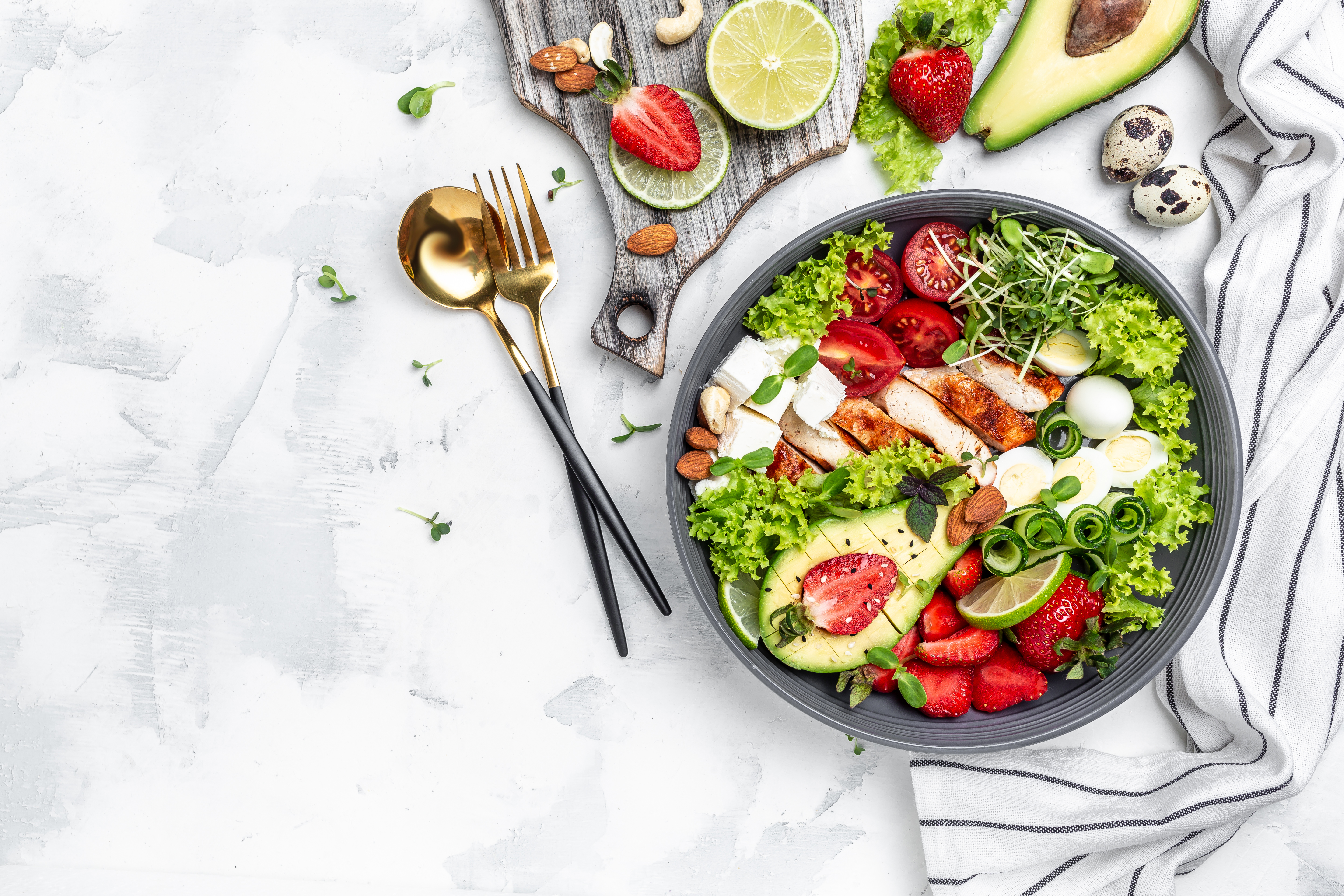 chicken-fillet-with-salad-with-avocado-feta-cheese-quail-eggs-strawberries-nuts-lettuce-white-background-healthy-food-keto-diet-diet-lunch-concept-top-view