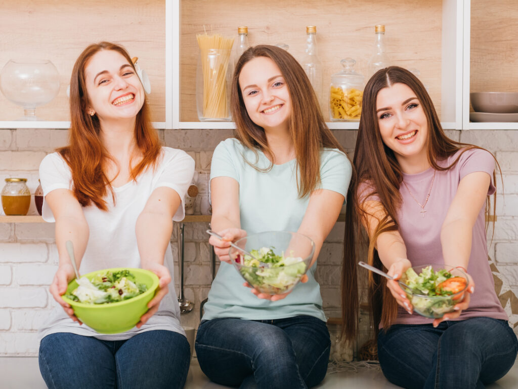 clean-eating-organic-recipe-healthy-whole-food-nutrition-smiling-young-females-with-salad-bowls-hands