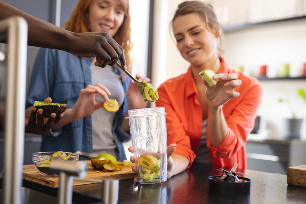 happy-diverse-friends-making-healthy-drink-together-kitchen