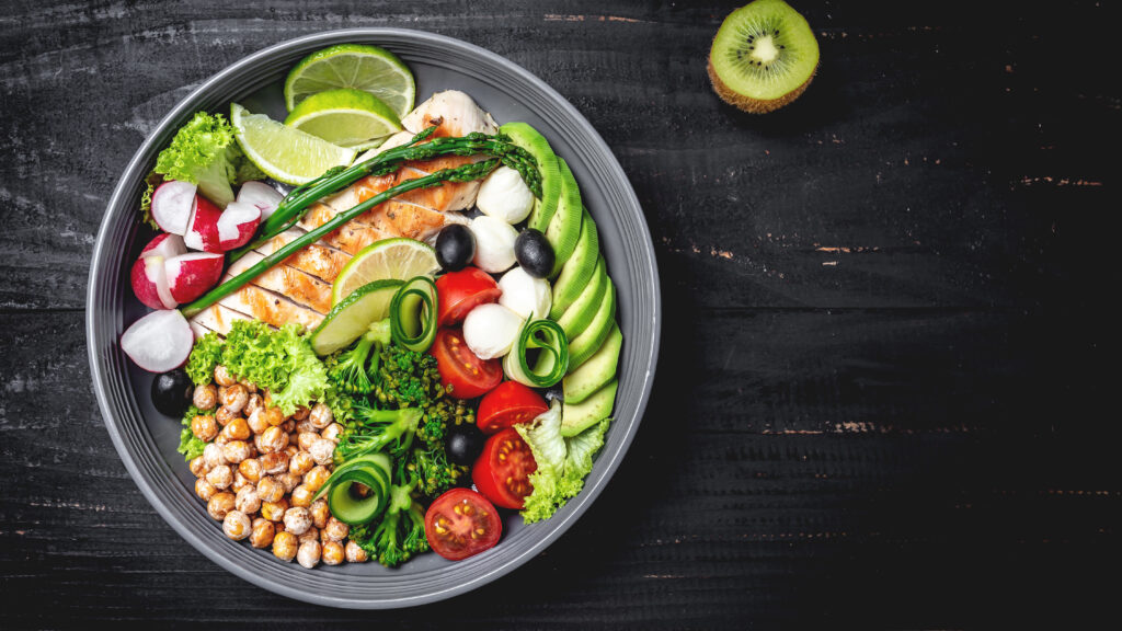 healthy-salad-bowl-with-avocado-asparagus-chickpeas-broccoli-radish-chicken-cucumber-tomatoes-olives-mozzarella-wooden-background-top-view-food-health